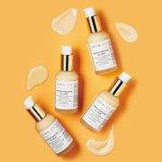 Four bottles of Farmacy's Honeymoon Glow laying next to smears of the 14% AHA resurfacing night serum