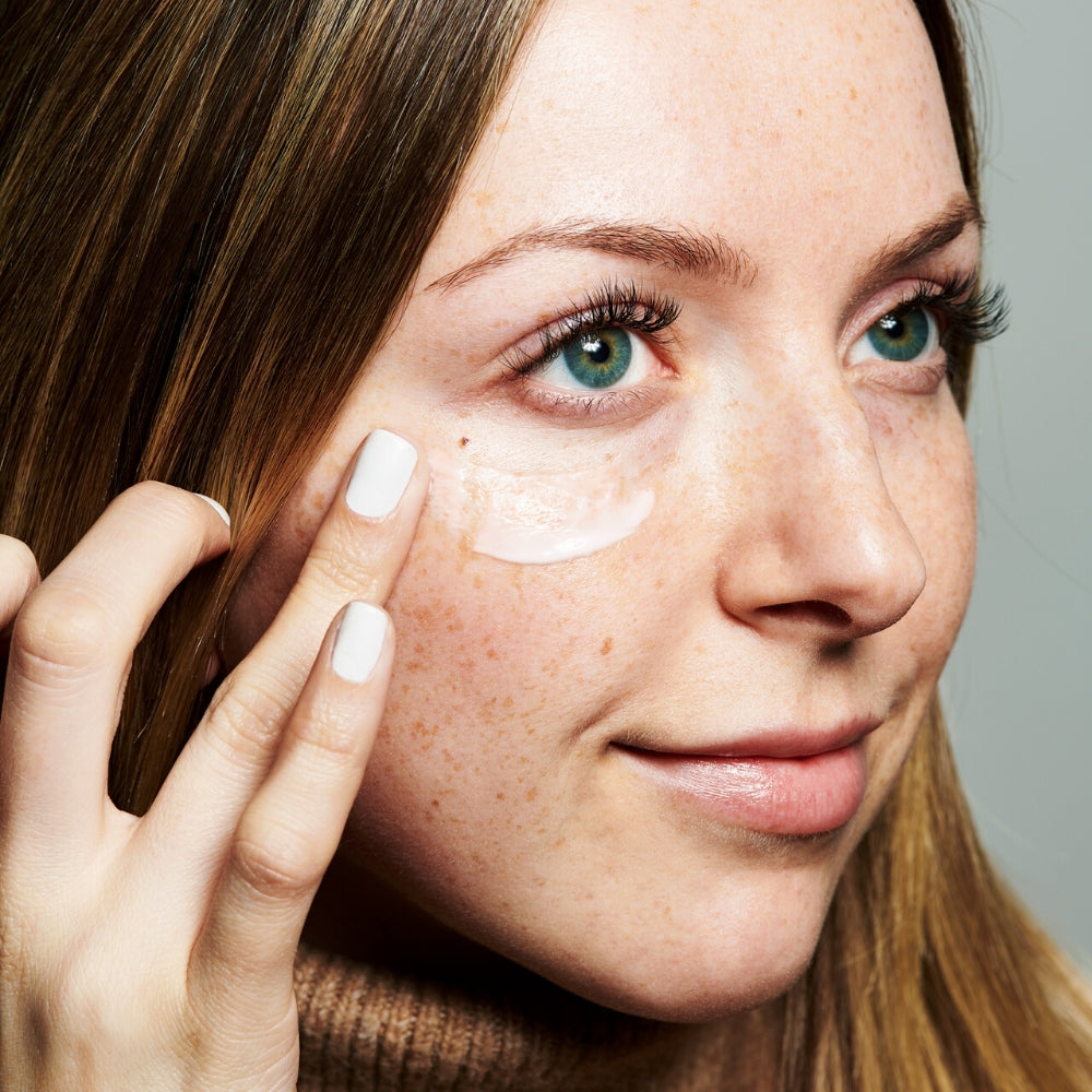 A woman applying a smear of Farmacy's Cheer Up to the side of her face