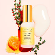A bottle of Farmacy's Filling Good Mini laying in front of a smear of the serum and vegan collagen peptides
