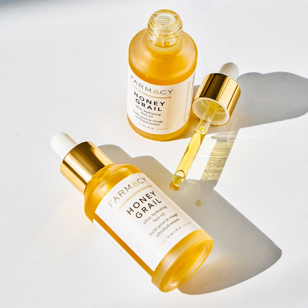 An open bottle of Farmacy Honey Grail antioxidant facial oil standing next to another bottle 