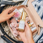 A woman removing a bottle of Farmacy's Honeymoon Glow from a makeup bag