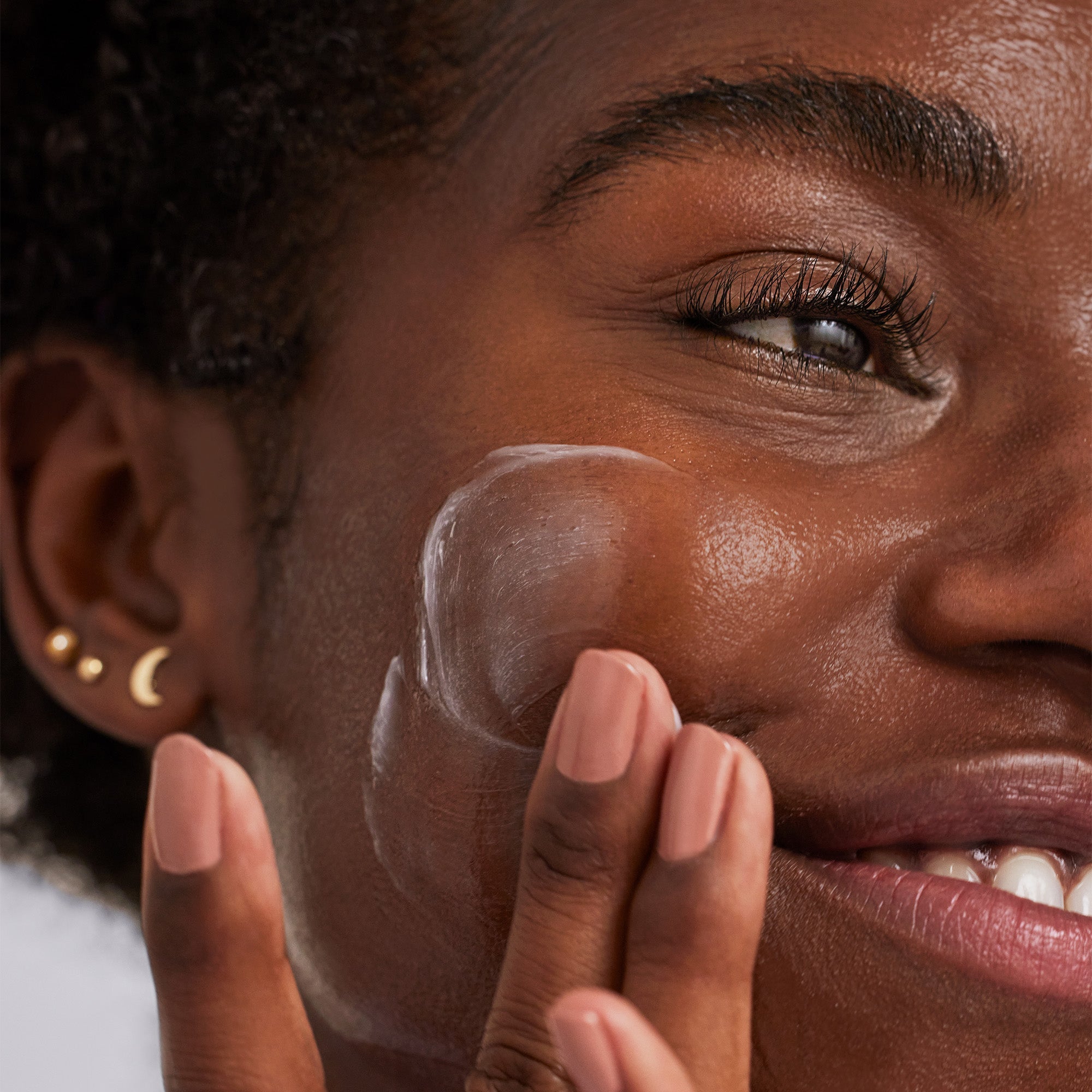 A woman applying the 10% Niacinamide Night Mask to her face