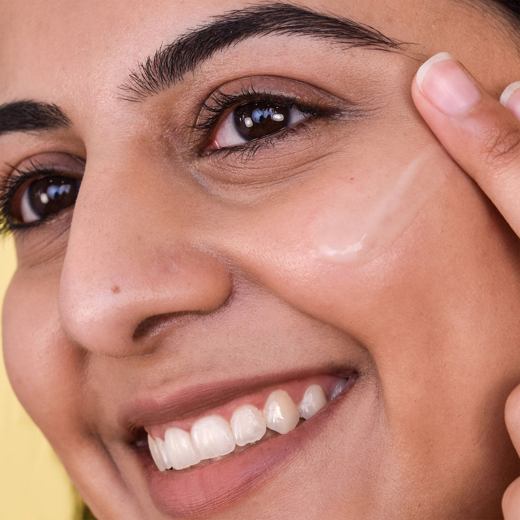 A woman applying a smear of Farmacy's Filling Good Mini Hyaluronic Acid Plumping Serum to her face